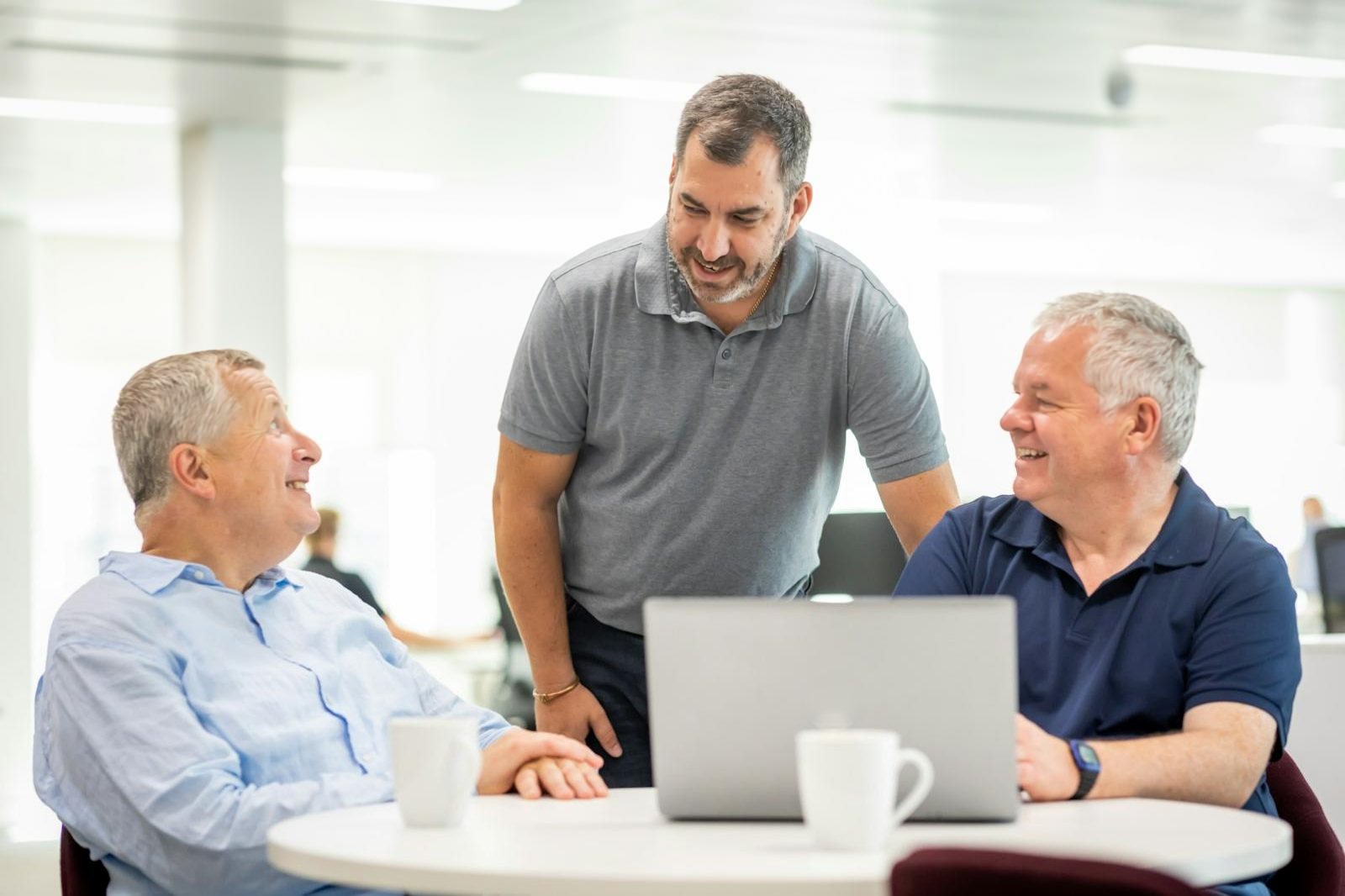 Financial advisors talking together around a laptop